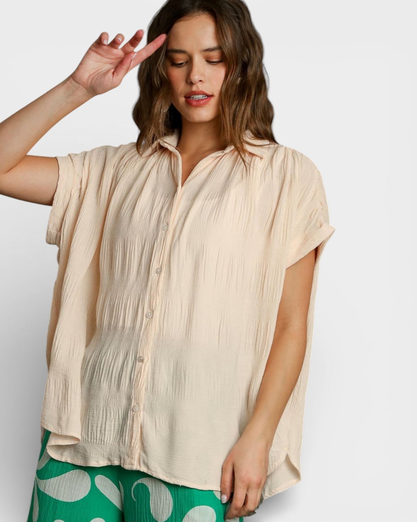 Woman wearing a beige blouse with a plain background