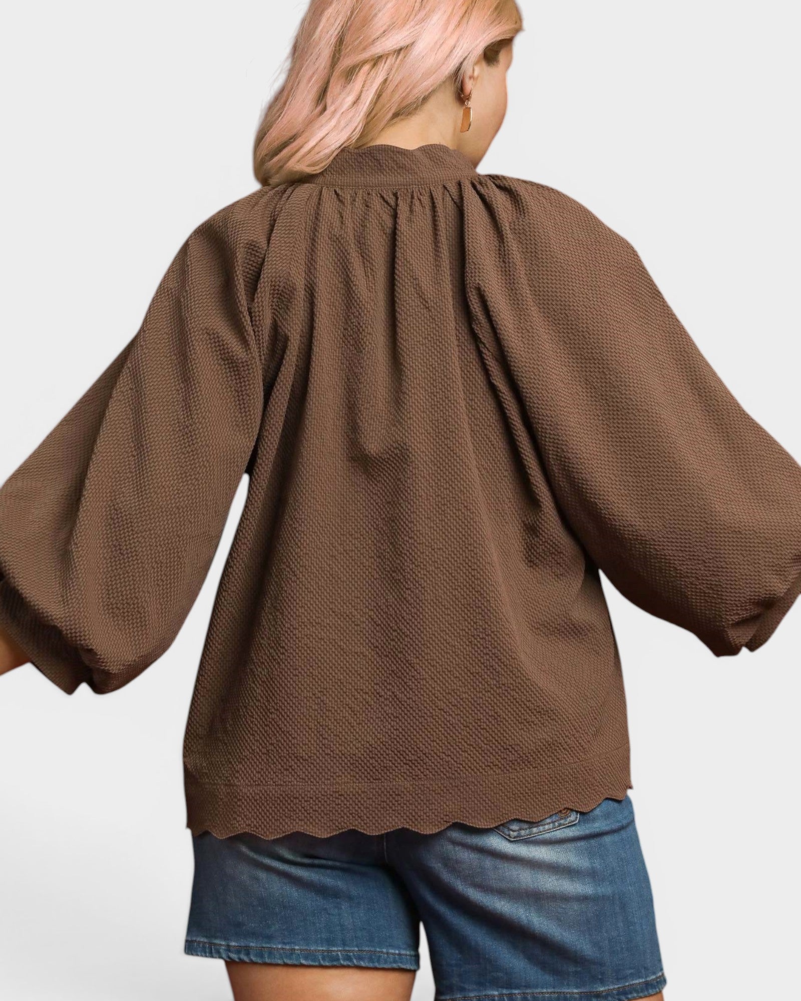 Brown textured blouse worn by a person on a white background