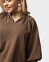 Woman wearing a brown textured blouse with a plain background
