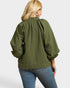 Person wearing a green blouse with puffed sleeves on a white background