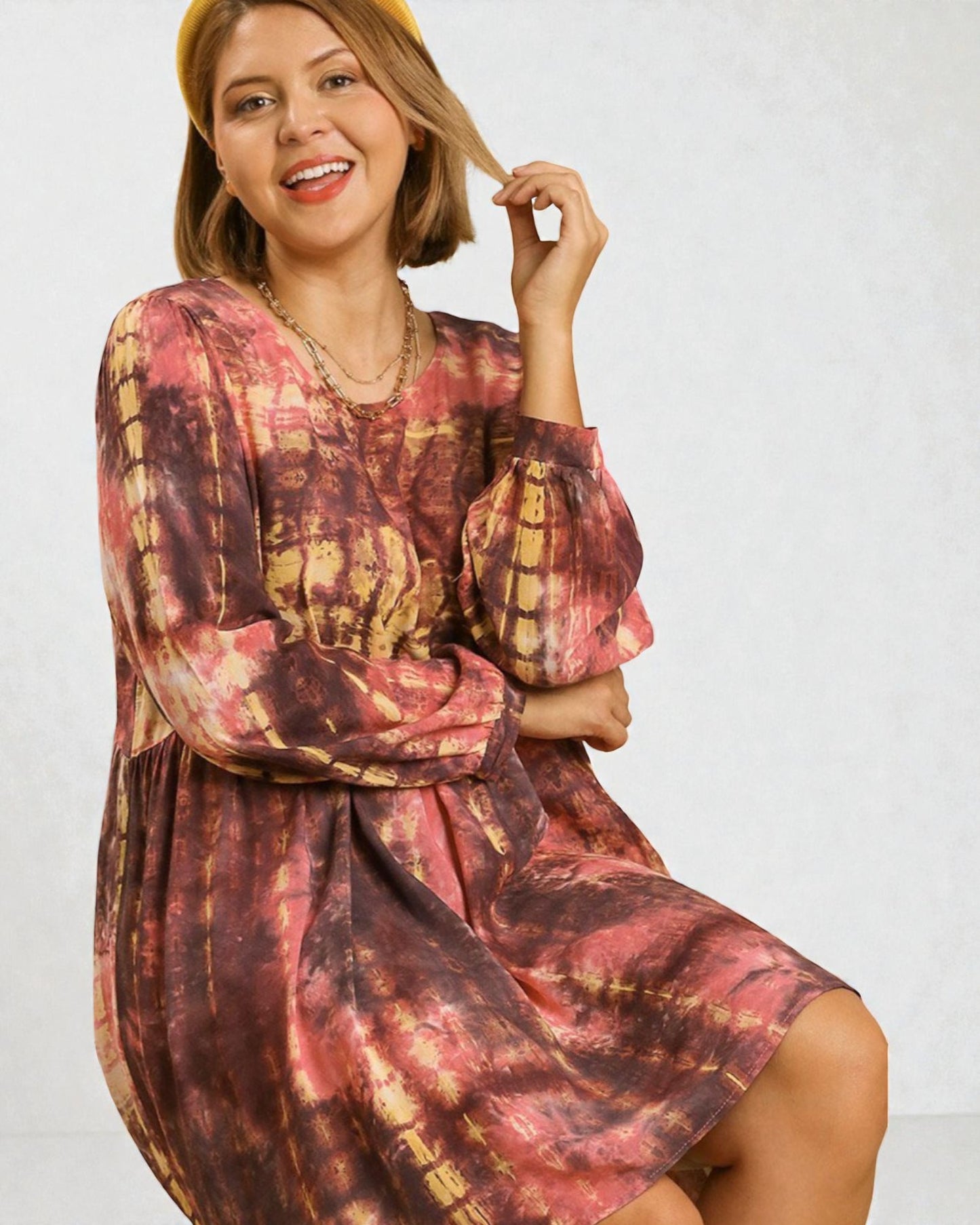 Woman wearing a tie-dye dress with a plain background