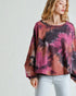 Woman wearing a tie-dye long-sleeve top with a plain background