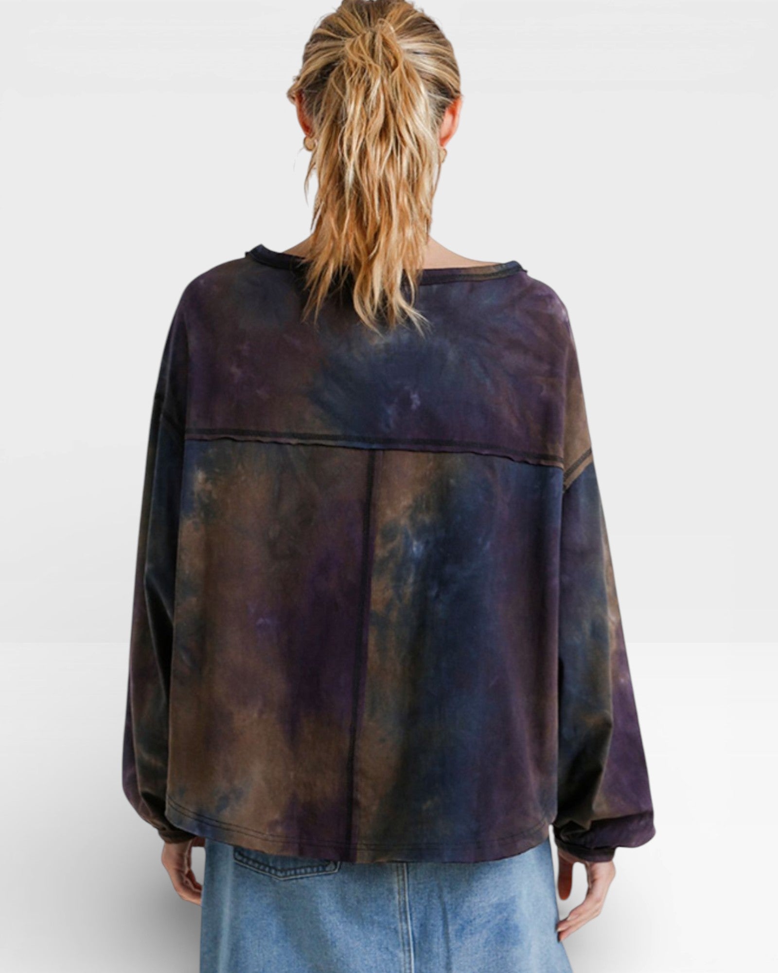 Person wearing a tie-dye shirt with a white background