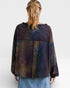 Person wearing a tie-dye shirt with a white background