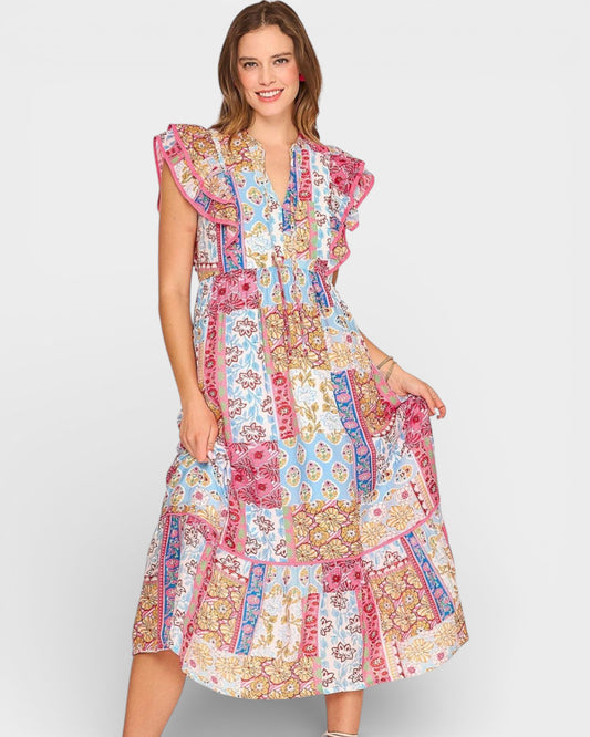 Woman wearing a colorful patchwork dress on a plain background