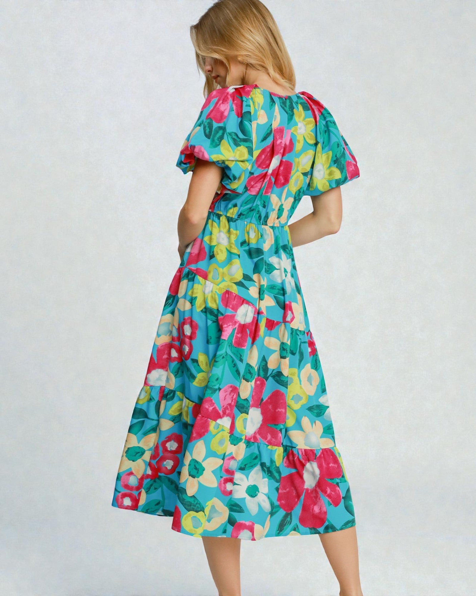 Woman wearing a colorful floral dress on a white background