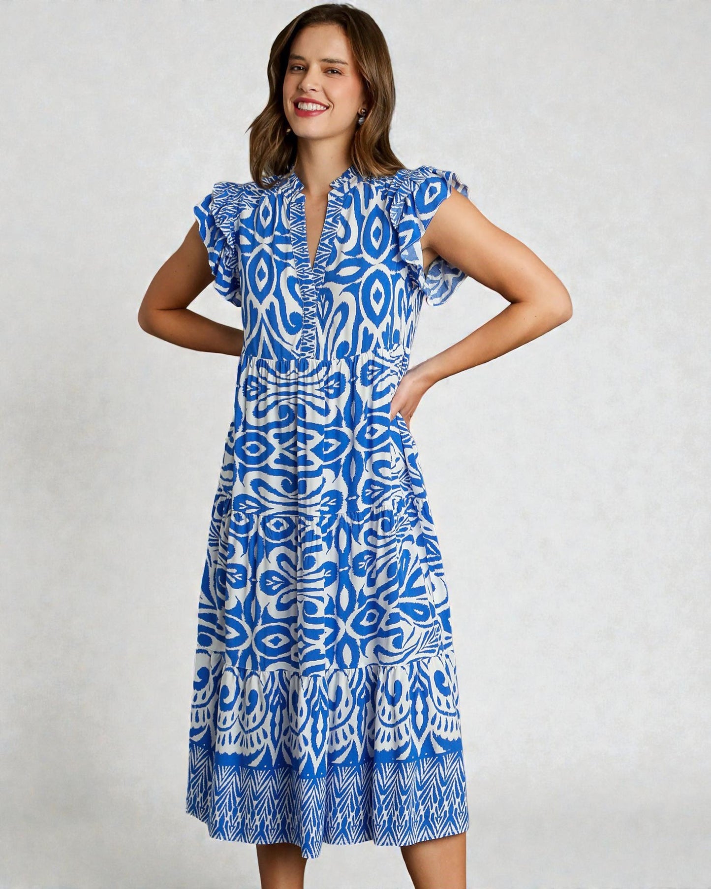 Woman wearing a blue and white patterned dress on a light gray background