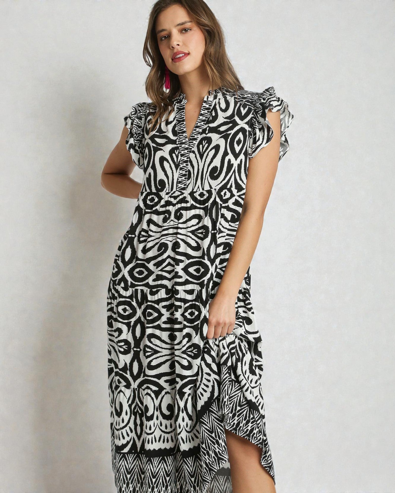 Woman wearing a black and white patterned dress on a plain background