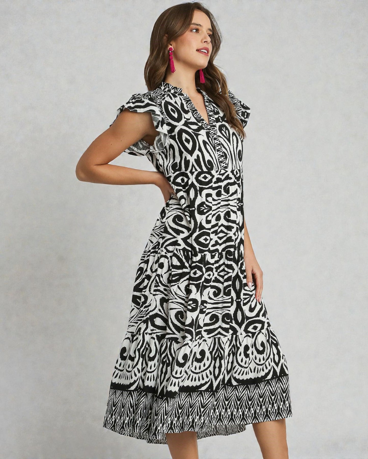 Woman wearing a black and white patterned dress on a gray background