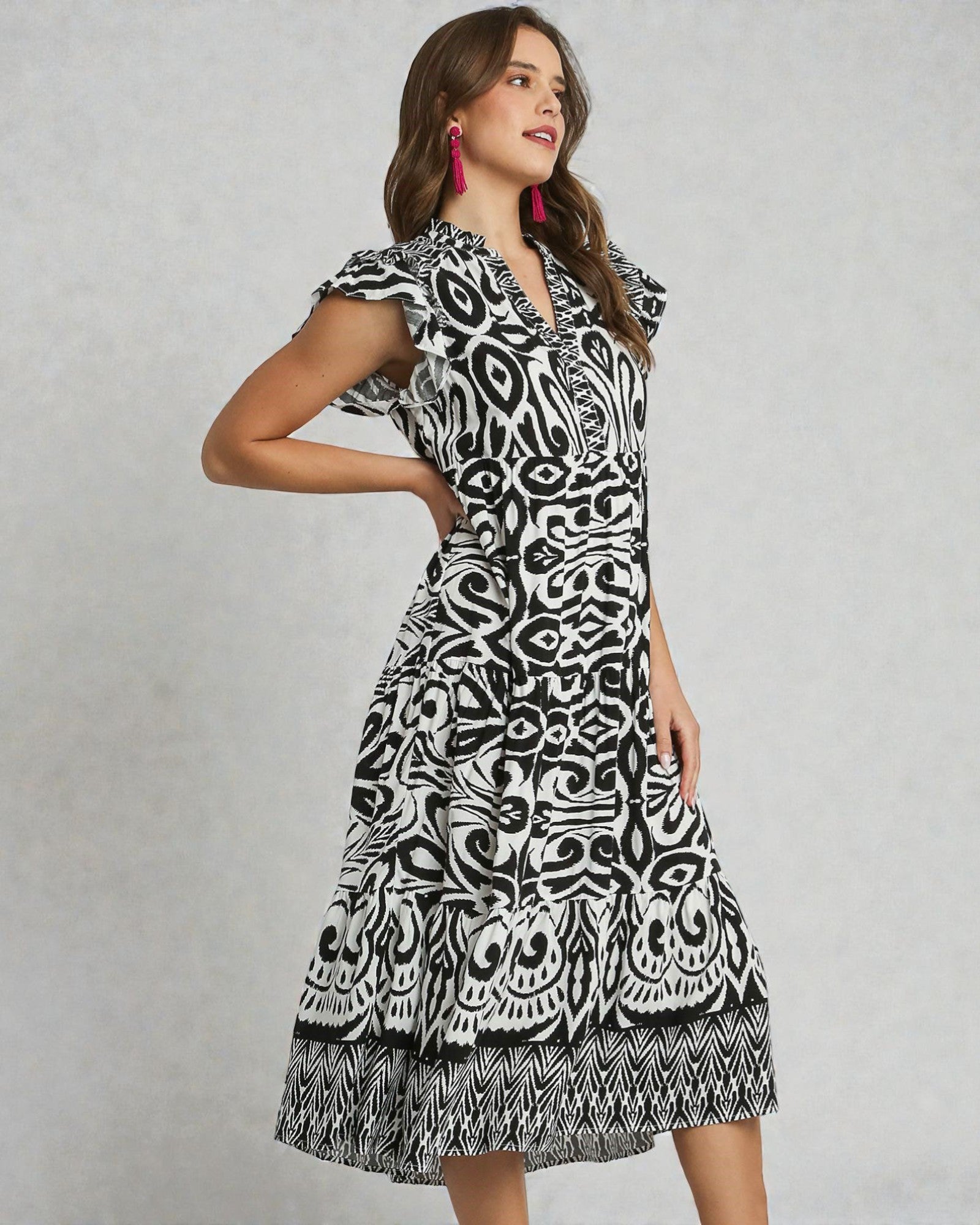 Woman wearing a black and white patterned dress on a gray background