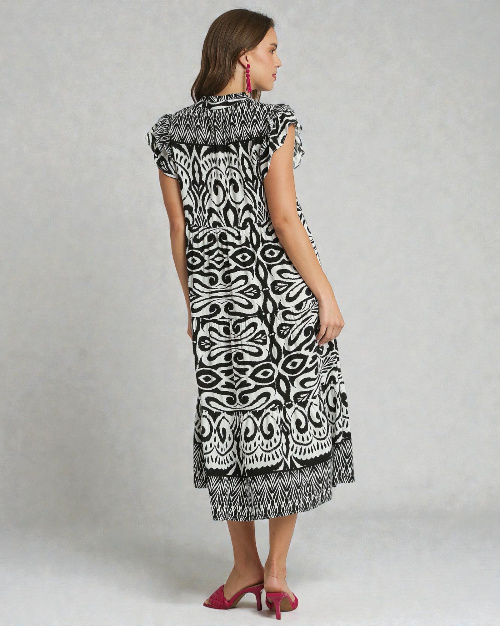 Woman wearing a black and white patterned dress on a gray background