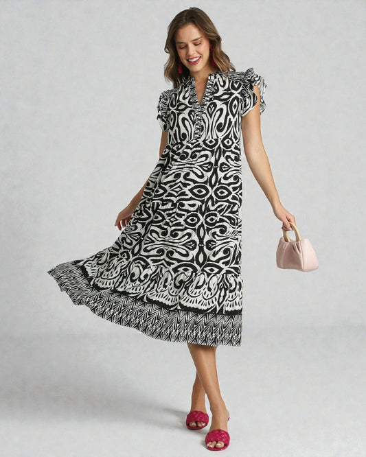 Woman wearing a black and white patterned dress on a gray background