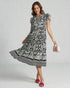 Woman wearing a black and white patterned dress on a gray background