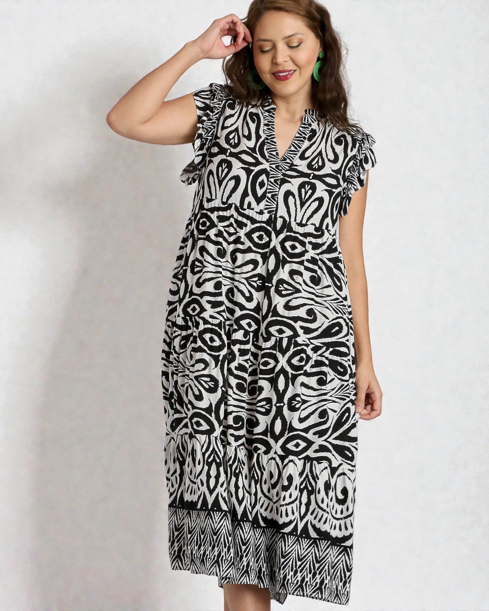 Woman wearing a black and white patterned dress on a plain background