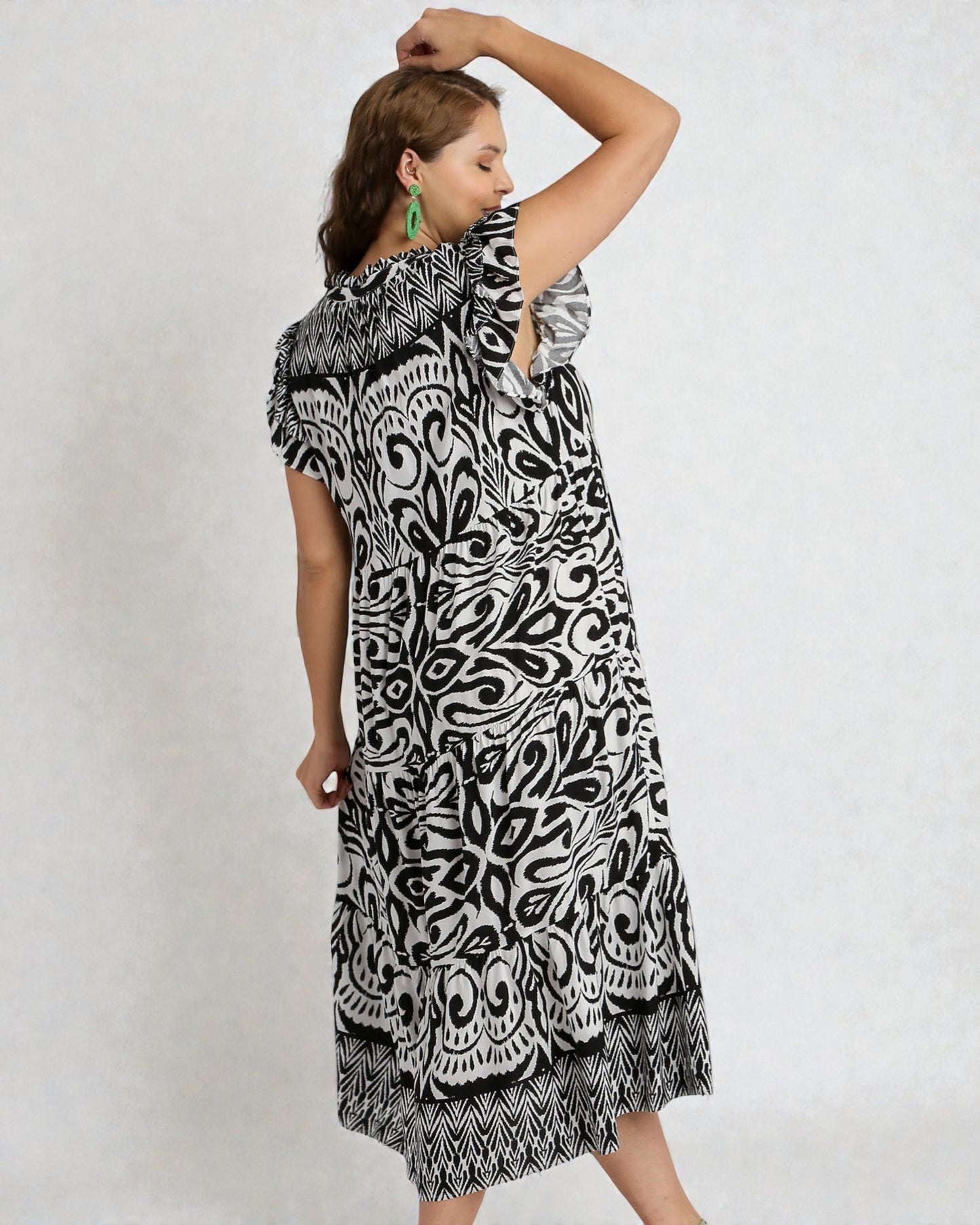 Woman wearing a black and white patterned dress on a plain background