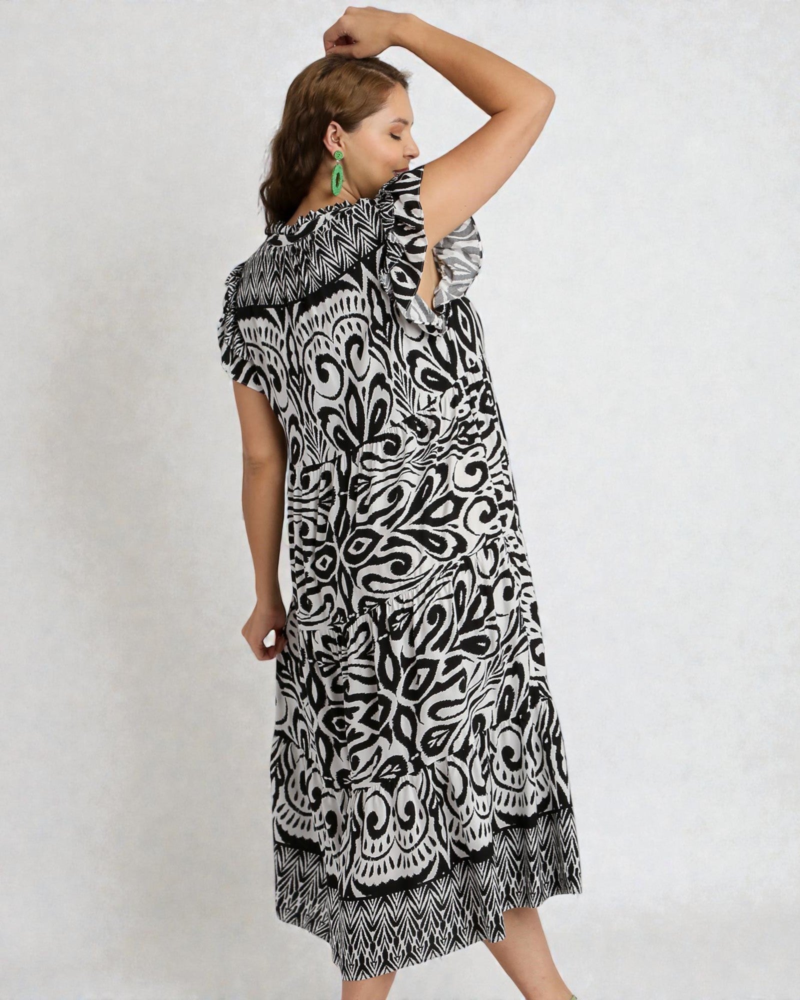 Woman wearing a black and white patterned dress on a plain background