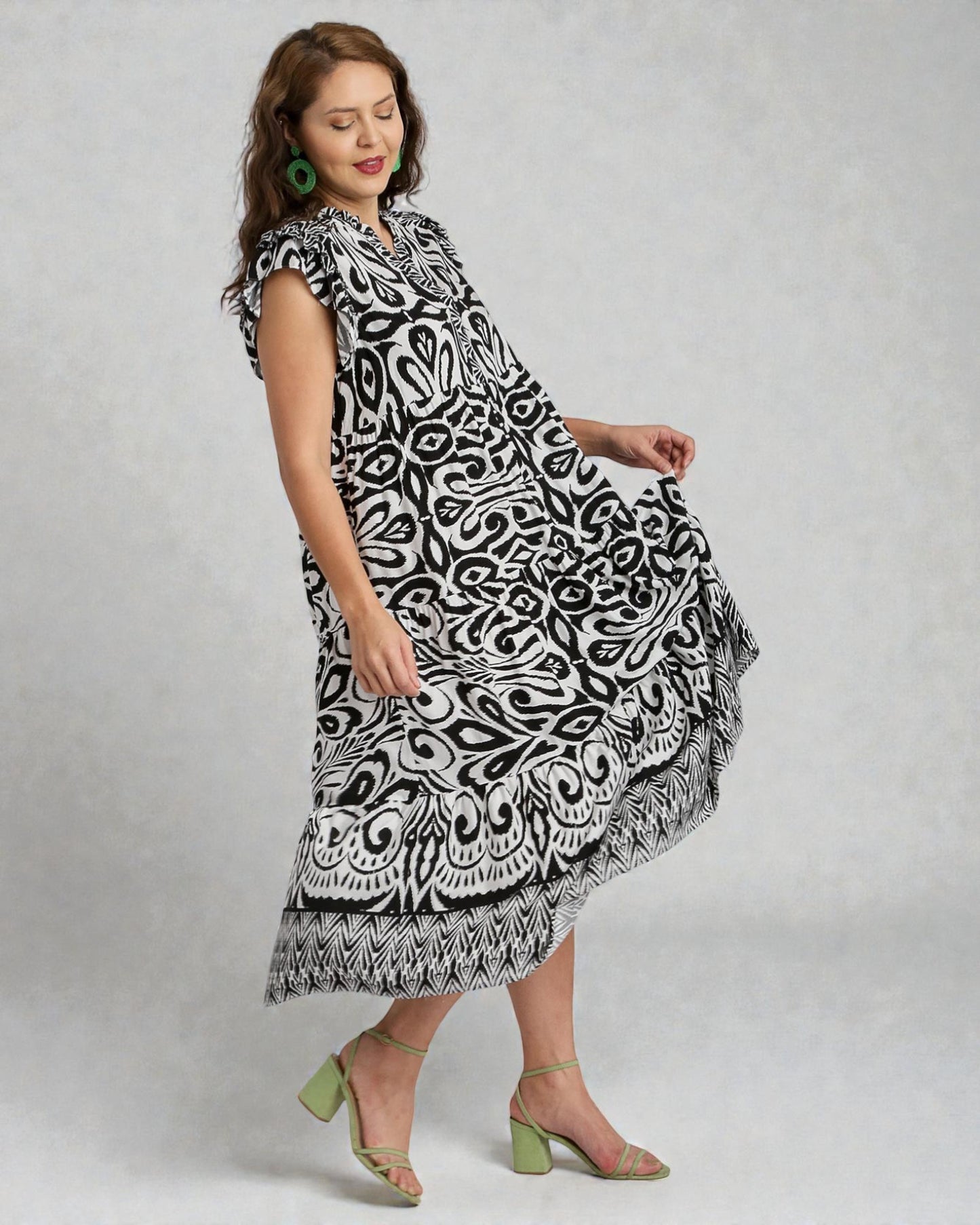 Woman wearing a black and white patterned dress on a gray background