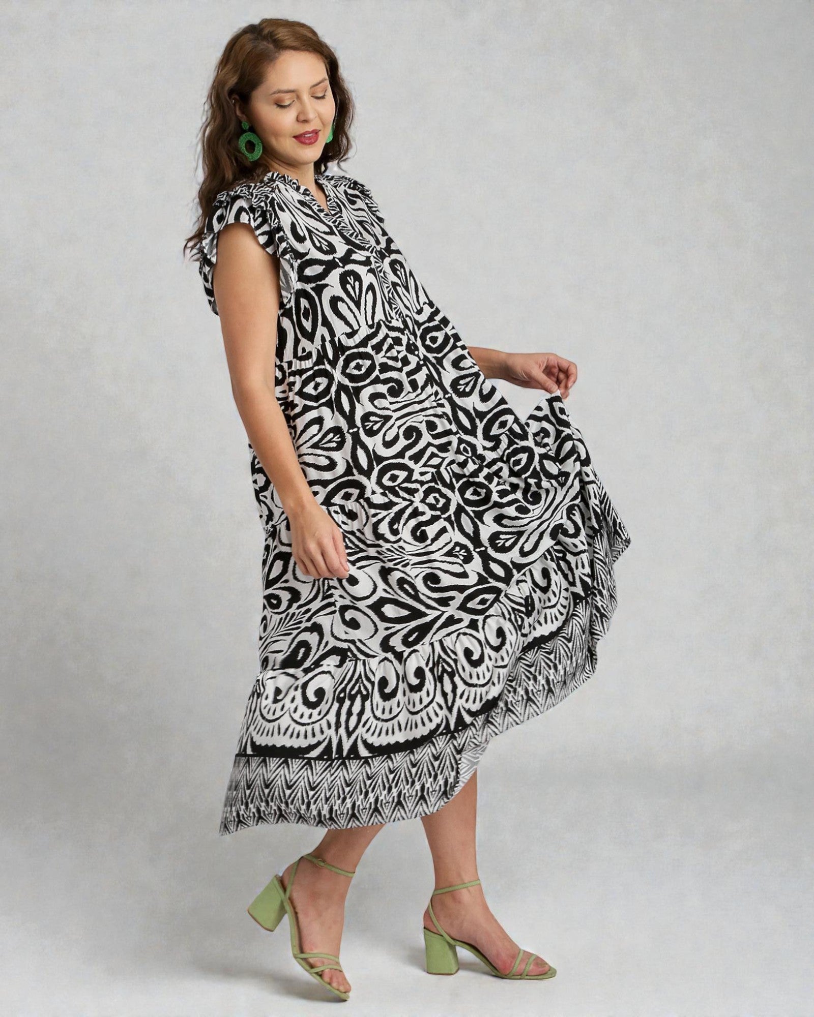 Woman wearing a black and white patterned dress on a gray background