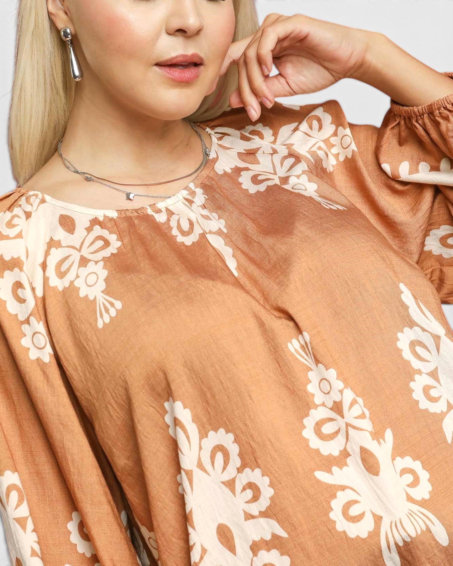 Close-up of a person wearing a brown dress with white lace details.