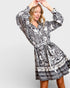 Woman wearing a black and white patterned dress on a light gray background
