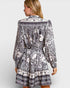 Woman wearing a black and white patterned dress on a white background