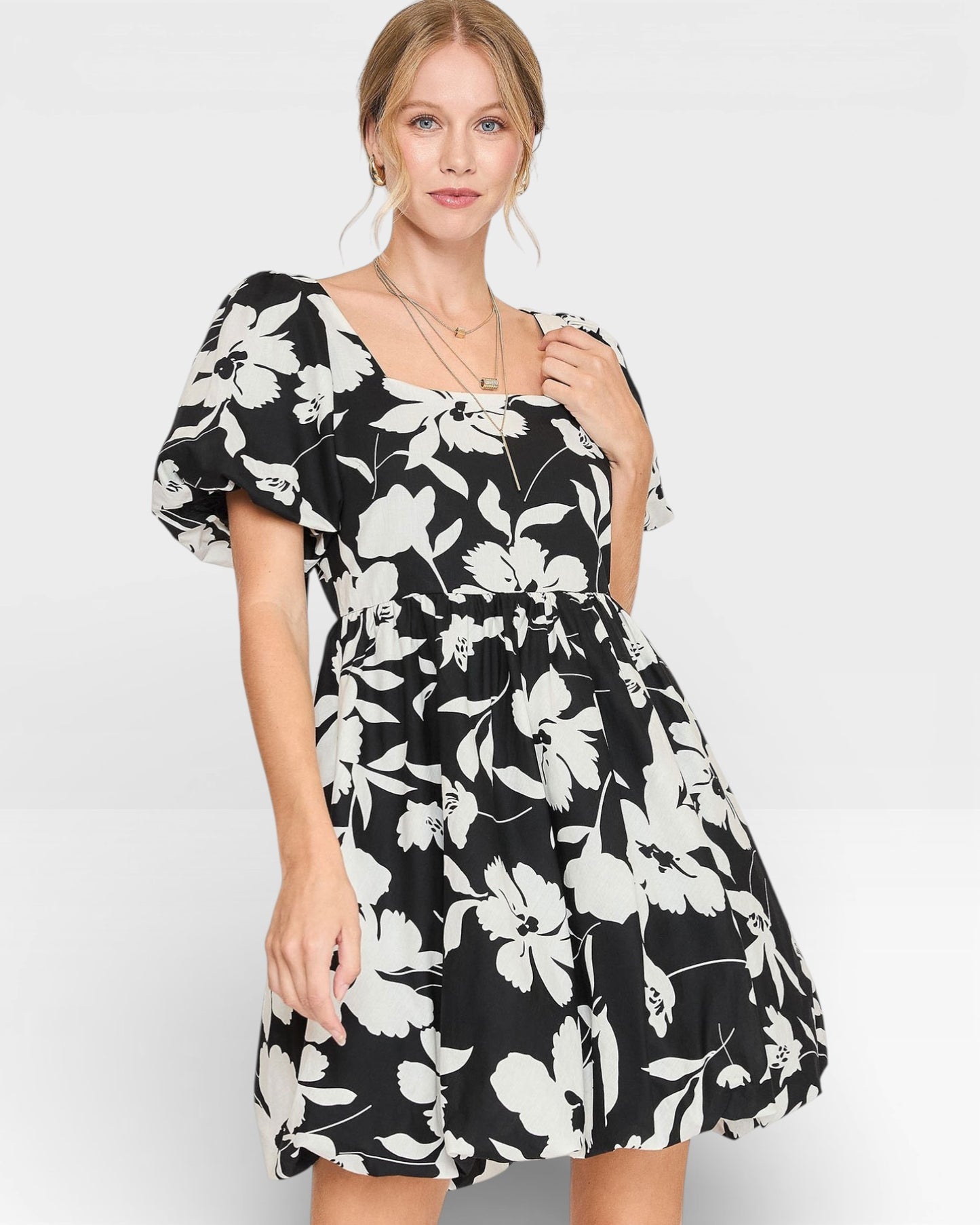 Woman wearing a black floral dress on a white background