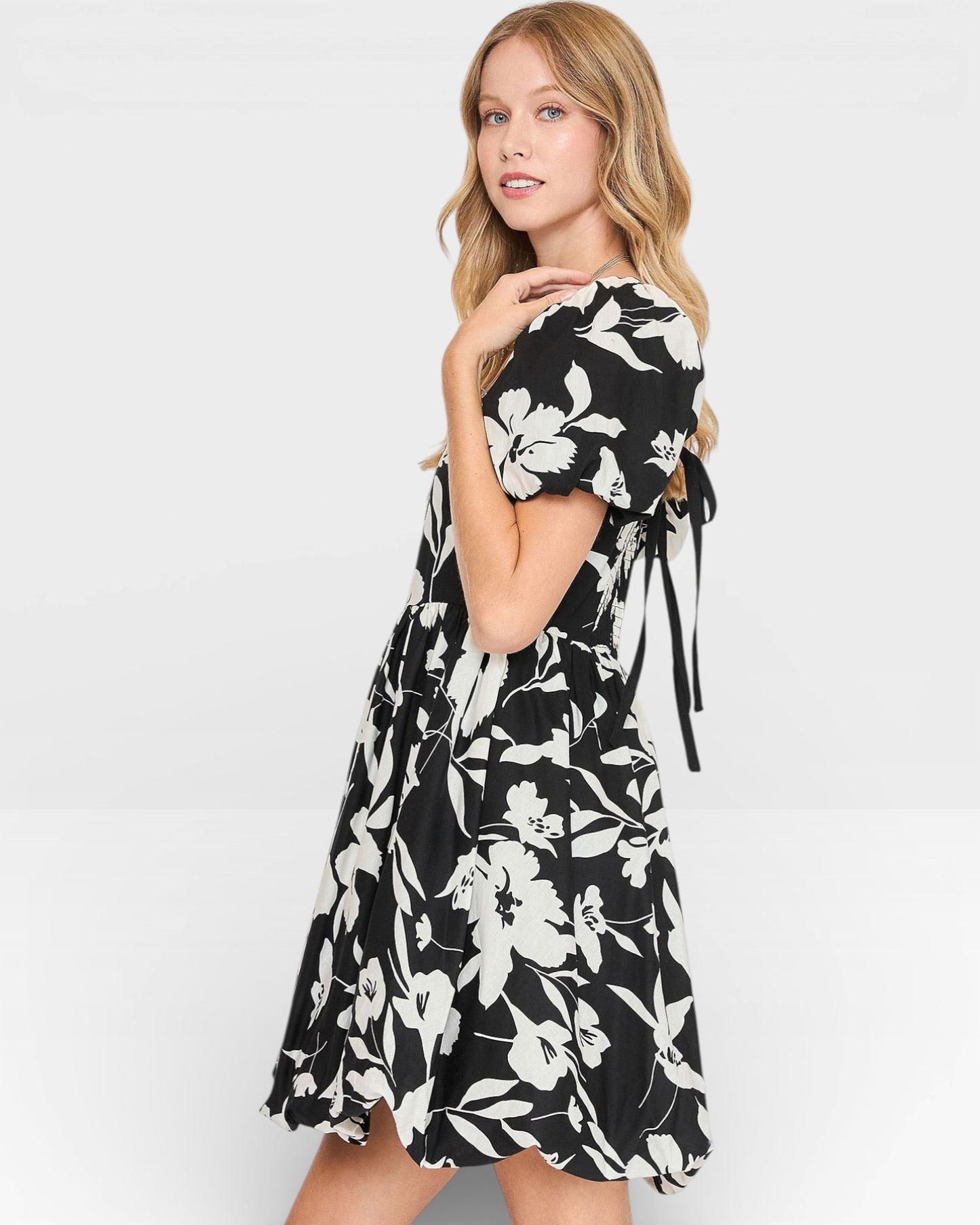 Woman wearing a black and white floral dress on a white background