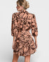 Woman wearing a patterned dress on a plain background