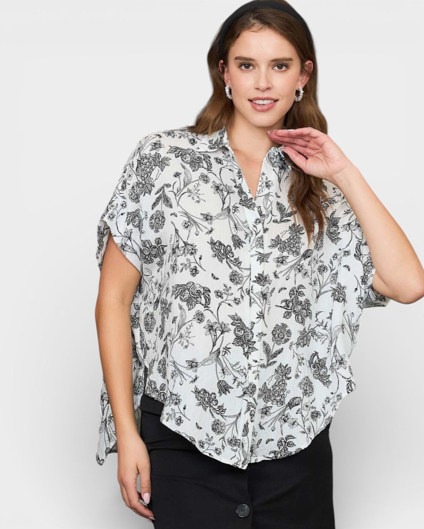 Woman wearing a floral blouse against a plain background