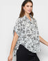 Woman wearing a floral blouse with a plain background