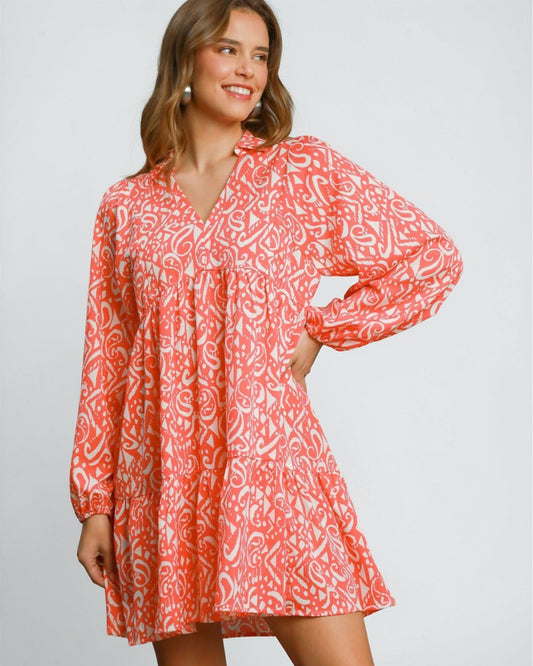 Woman wearing a red and white patterned dress on a plain background