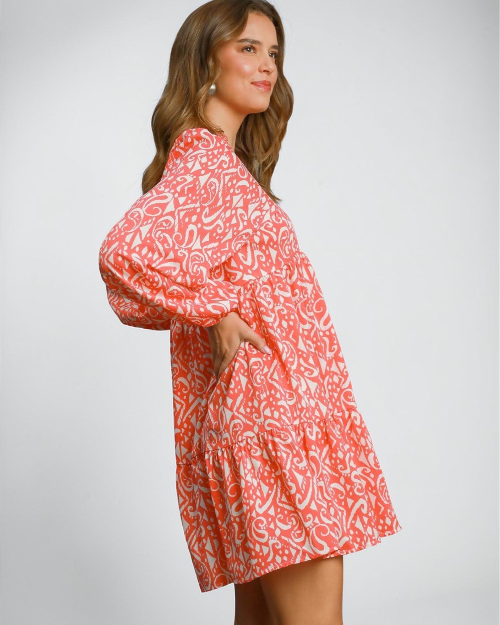 Woman wearing a red and white patterned dress on a plain background
