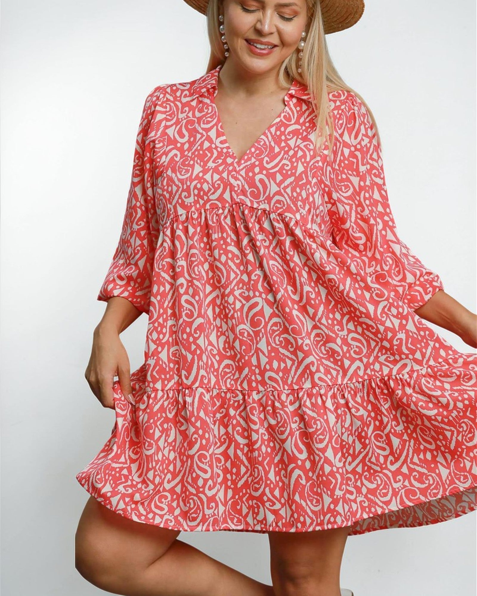 Woman wearing a red and white patterned dress on a plain background