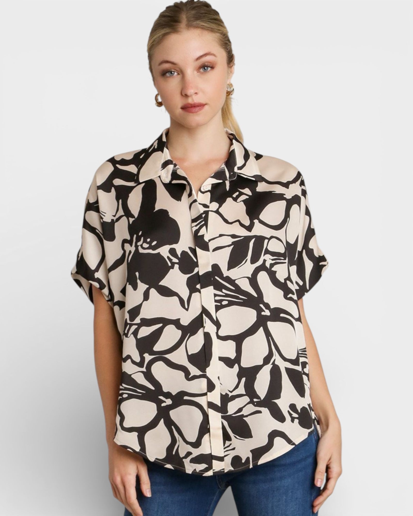 Woman wearing a patterned shirt with a plain background