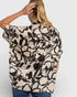 Woman wearing a floral patterned blouse with a plain background