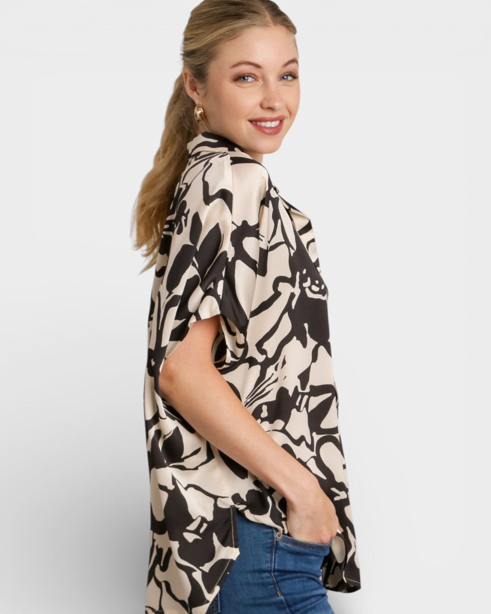 Woman wearing a patterned shirt with a plain background