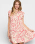 Woman wearing a pink and white patterned dress on a plain background