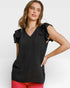 Woman wearing a black sleeveless top with ruffled shoulders on a white background