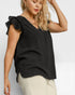 Woman wearing a black sleeveless top with ruffled shoulders on a white background