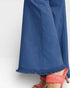 Blue pants with frayed hem and coral high-heeled shoes on a white background