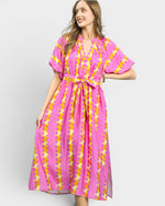 Woman wearing a pink and yellow patterned dress on a white background
