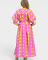 Woman wearing a pink and yellow patterned dress on a white background