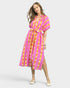 Woman wearing a pink and yellow tie-dye dress on a white background
