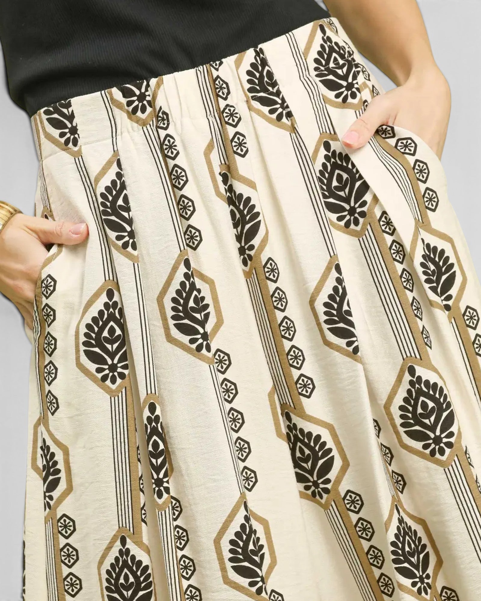 Patterned pants with black and gold design on a neutral background
