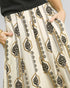 Patterned pants with black and gold design on a neutral background