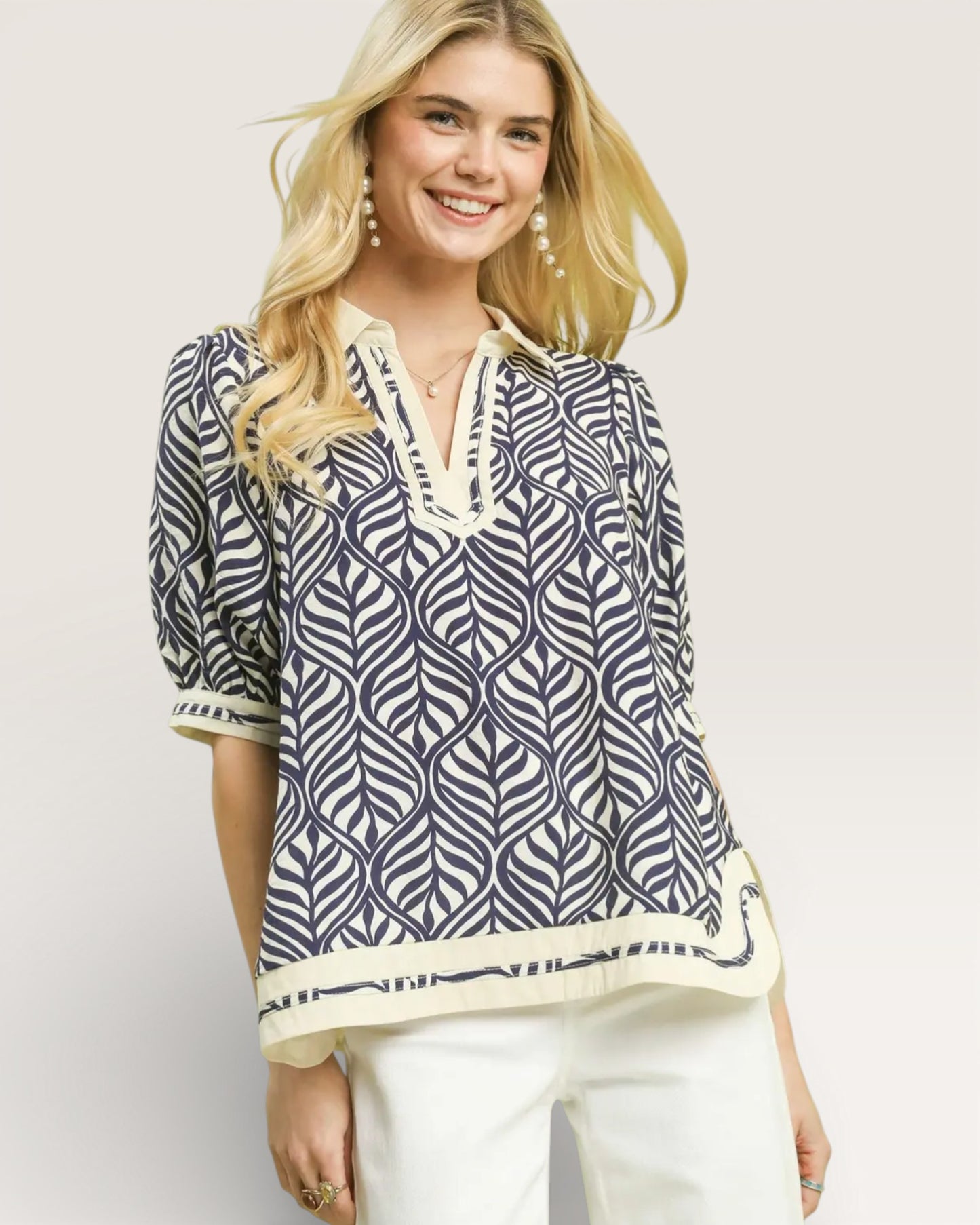 Woman wearing a patterned blouse with a plain background