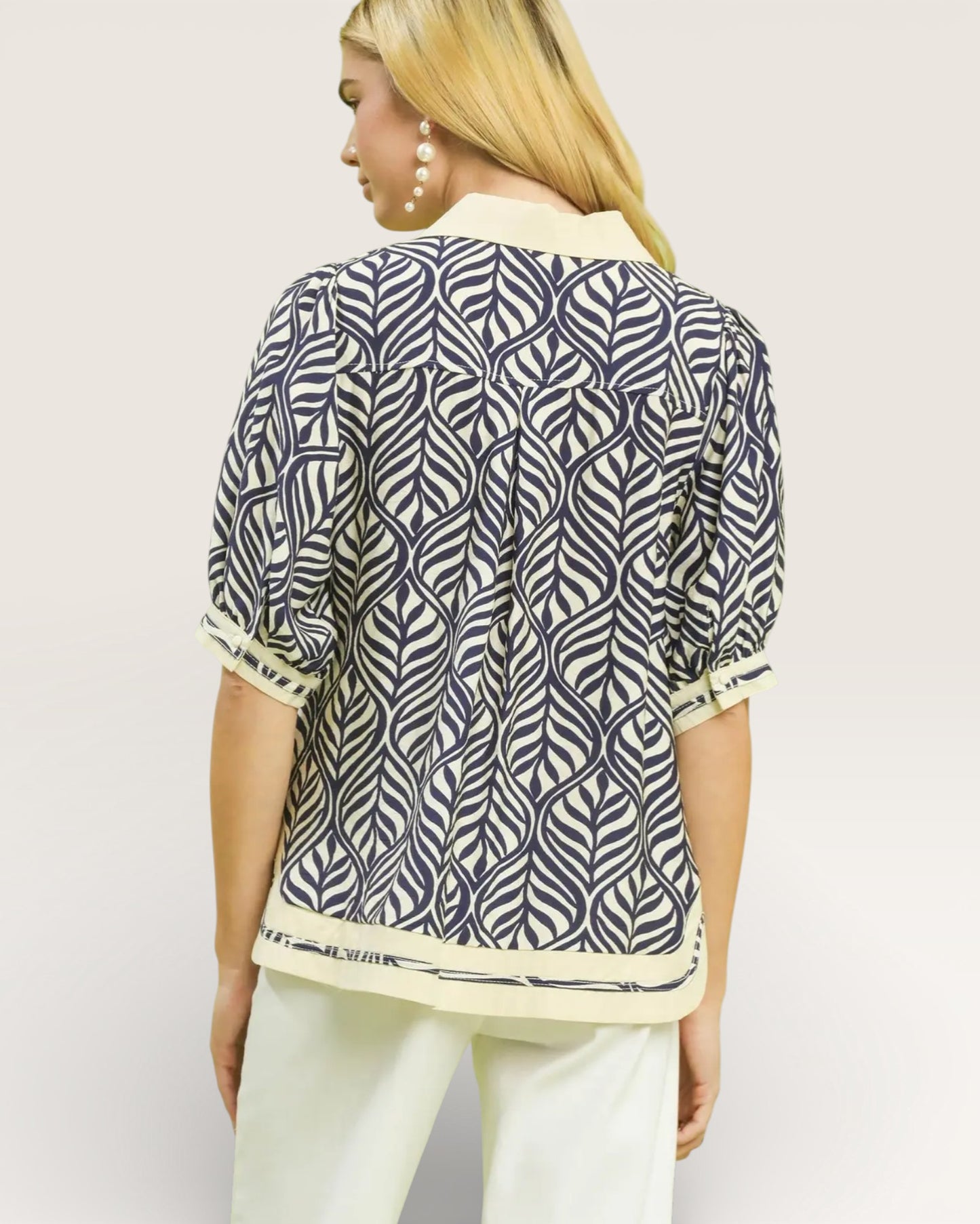 Woman wearing a patterned shirt with a plain background