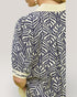 Person wearing a blue and white patterned shirt with a plain background
