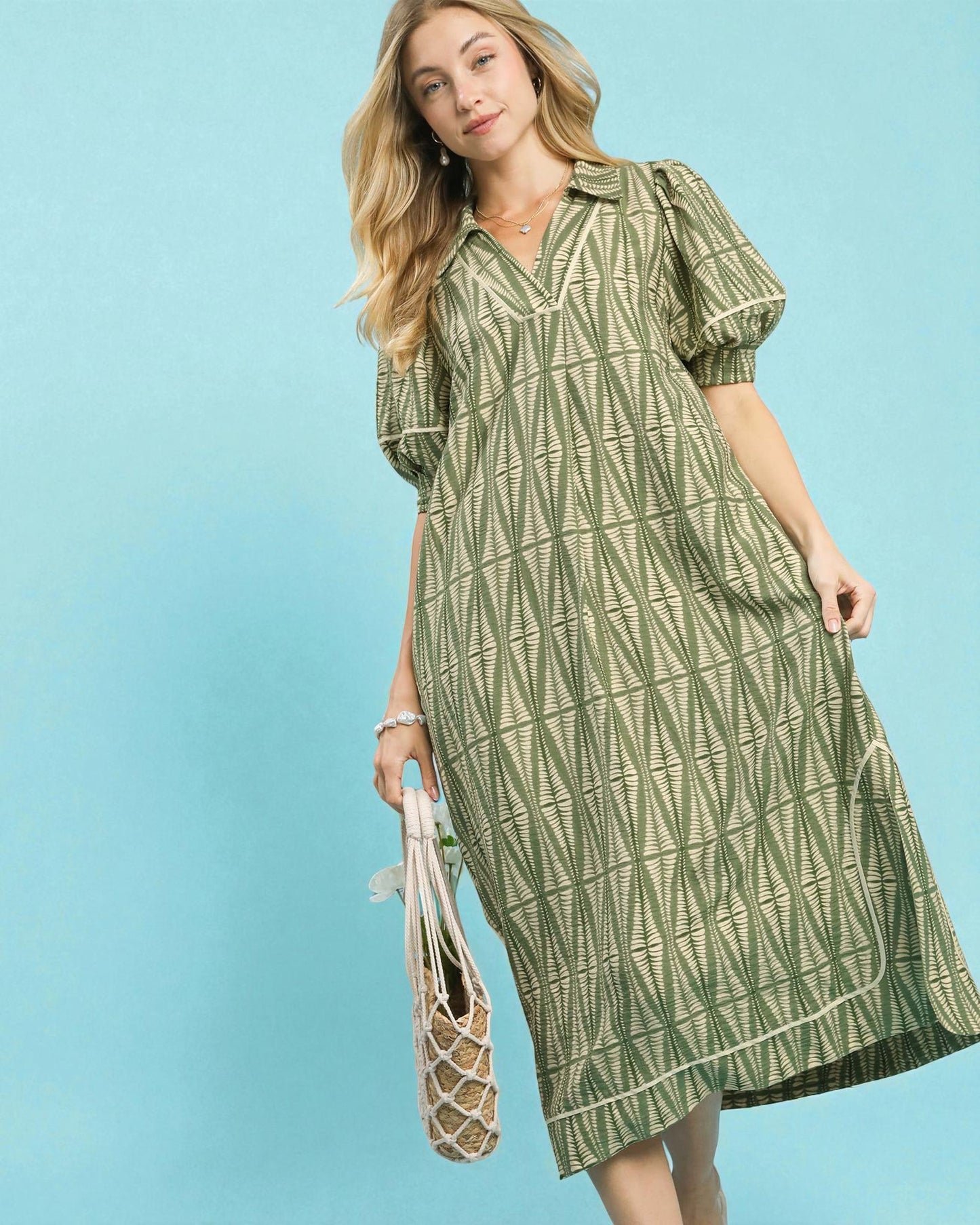 Woman wearing a green patterned dress against a blue background