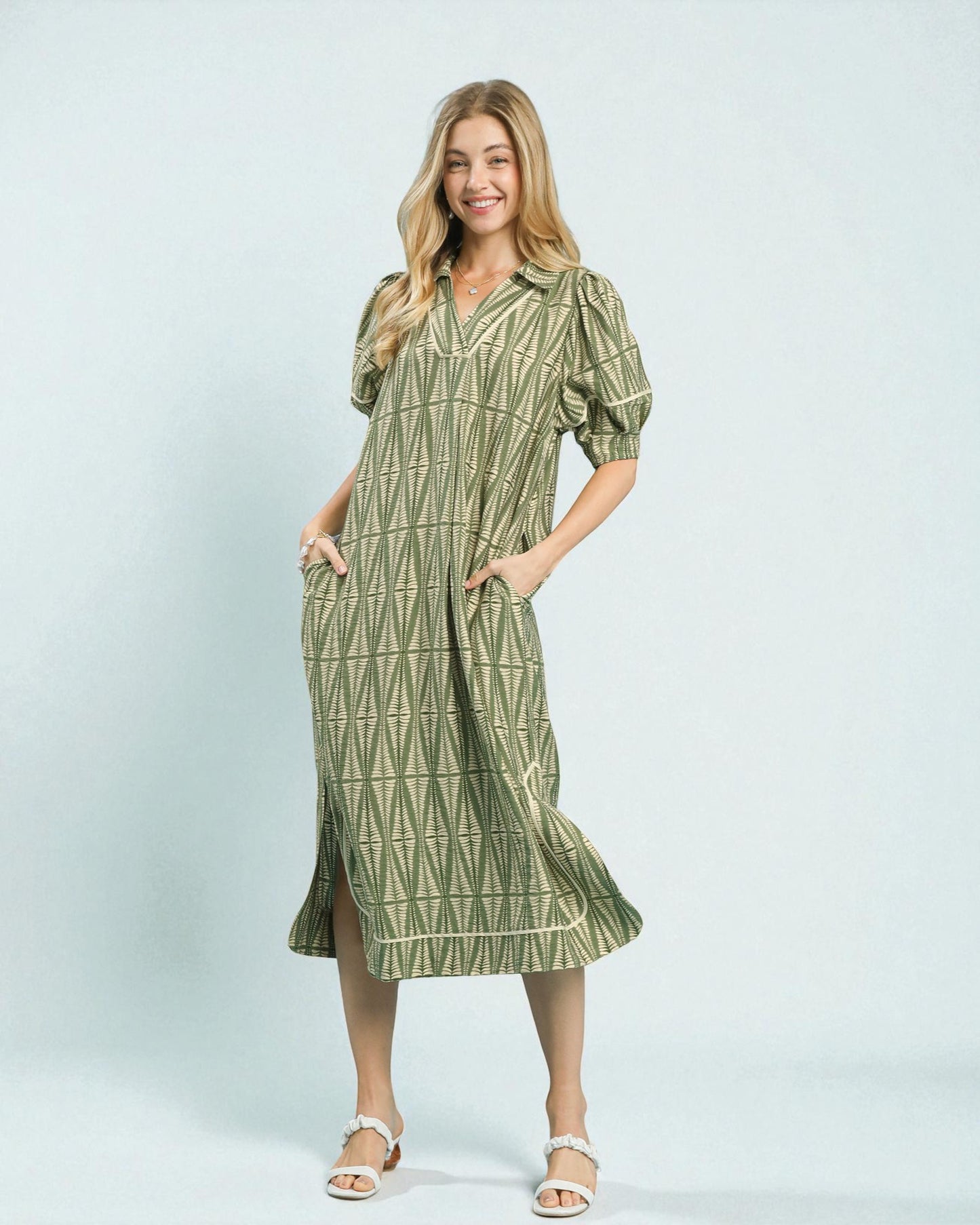 Woman wearing a green patterned dress on a white background
